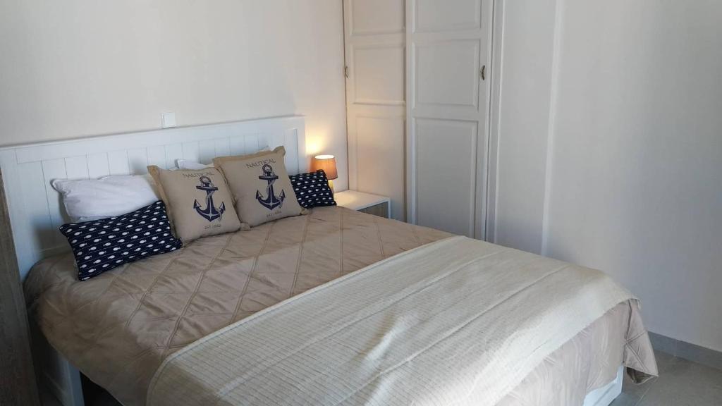 a bedroom with a bed with pillows on it at Happy Anchor Apartments in Kallithea Halkidikis