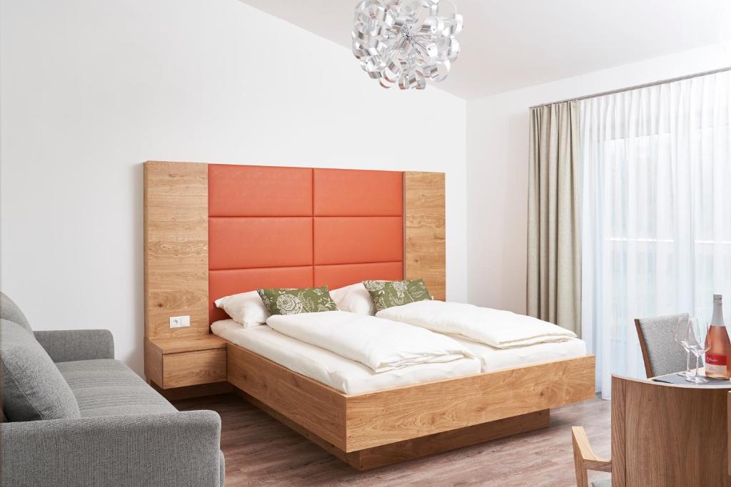 Angern的住宿－Weinhof - Gästehaus Maier，一间卧室配有一张床、一张沙发和一把椅子