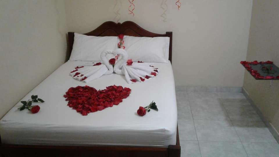 Una cama con un corazón hecho de rosas rojas en HOTEL EL CAMINANTE DEL LLANO, en Pore