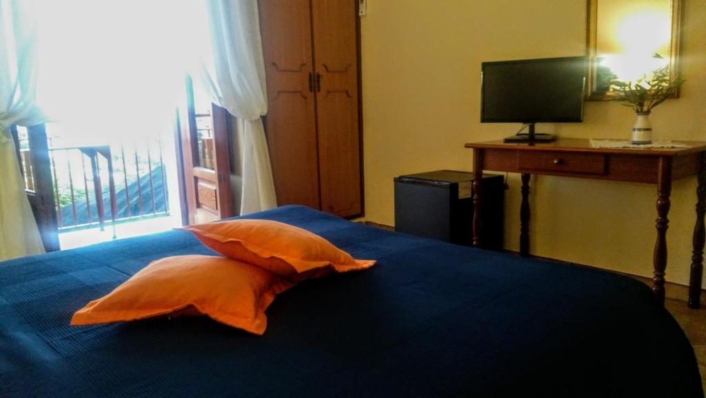 a bedroom with a blue bed with an orange pillow at Ravello View in Scala