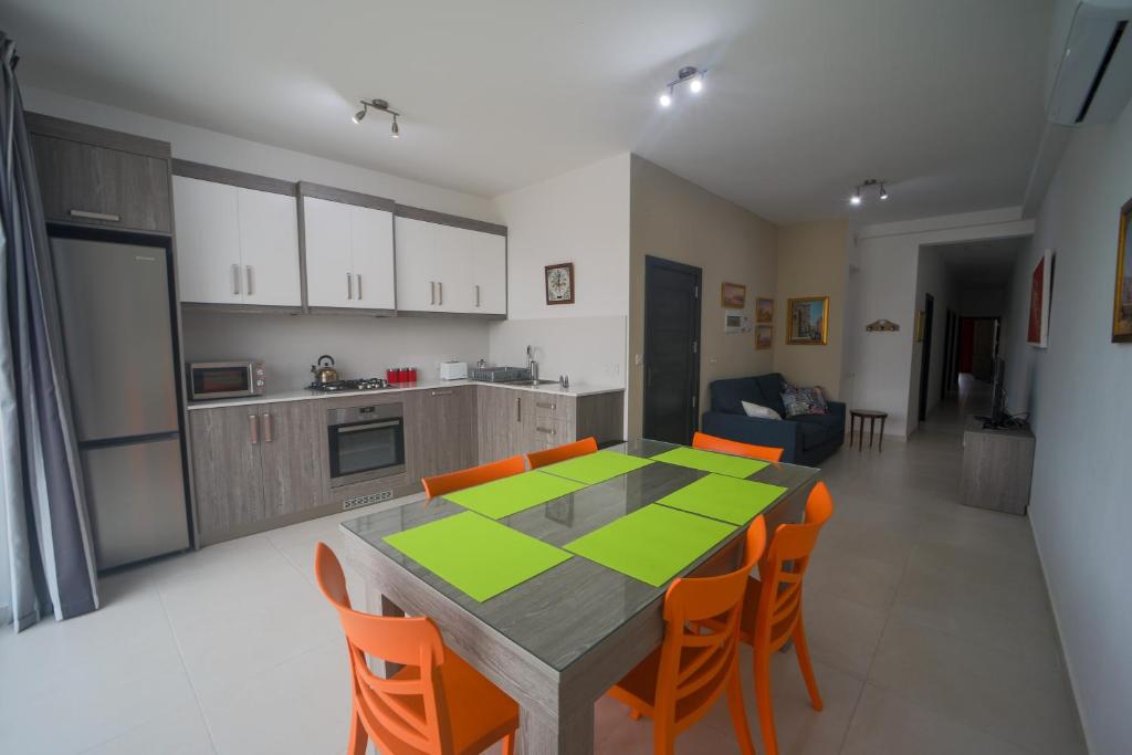 cocina y comedor con mesa y sillas en Island Break Residence en Marsalforn