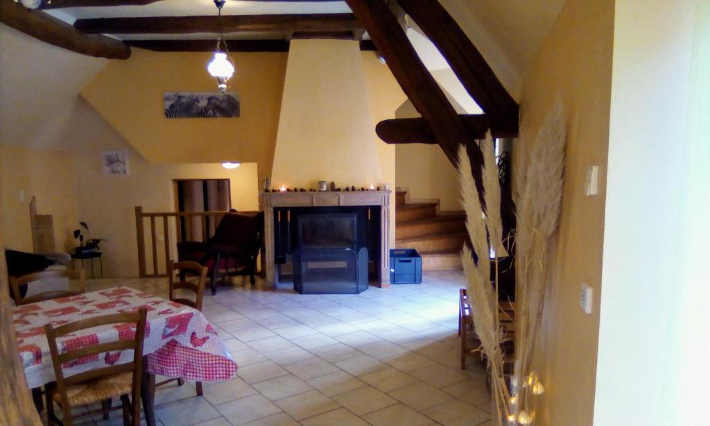 - un salon avec une table et une cheminée dans l'établissement Gîte de la licorne, à Moissey