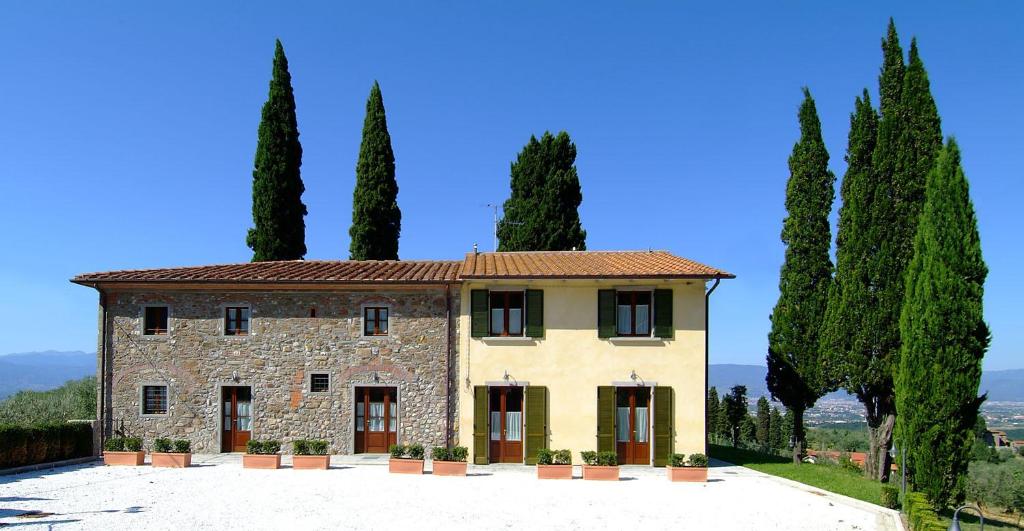 an italian villa with cypress trees in front at Poggio Desto Bed & Breakfast in Quarrata