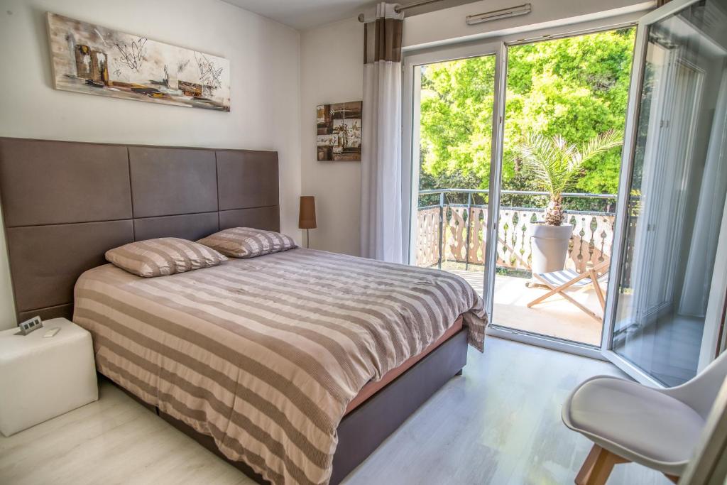 - une chambre avec un lit et un balcon dans l'établissement Appartement 90 m2 avec parking terrasse balcons, proche du port et plages, à Arcachon