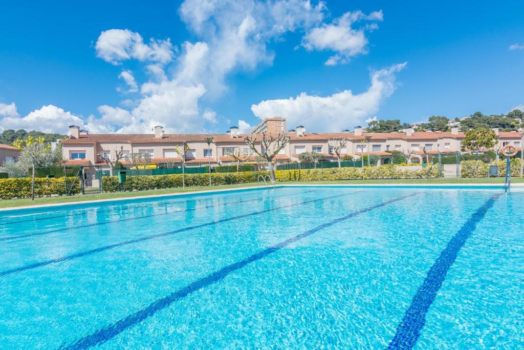 una gran piscina con edificios en el fondo en HomeHolidaysRentals Moonlight, en Santa Susanna