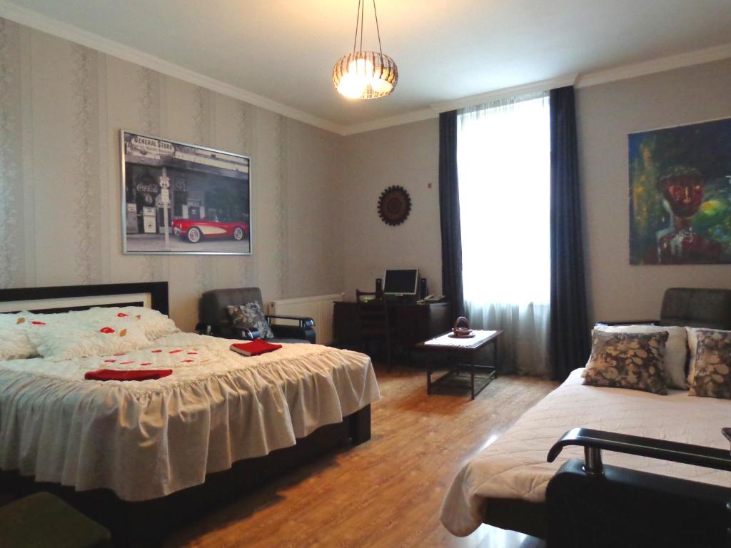 a bedroom with a bed and a couch and a window at Guest House, Old-Si in Tbilisi City