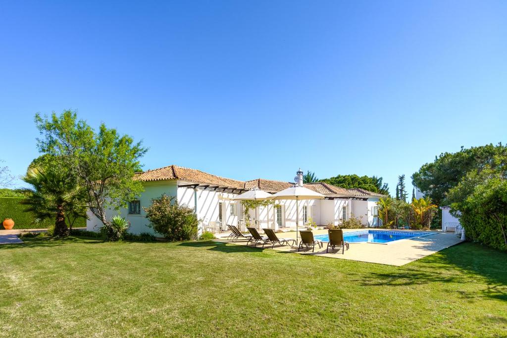 a house with a yard with chairs and a swimming pool at Exclusive Villa Toulouse with pool in Falesia Algarve in Albufeira