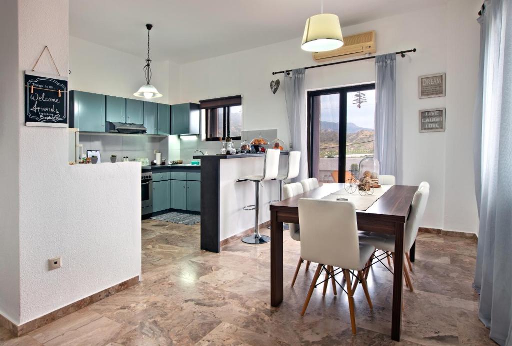 cocina y comedor con mesa y sillas en Sophie's Village House, en Myrtos