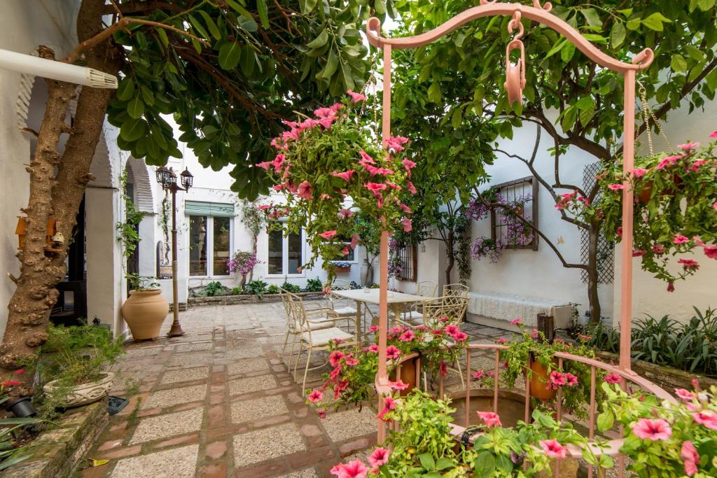 a courtyard with pink flowers and a table and chairs at Patio Márquez in Córdoba