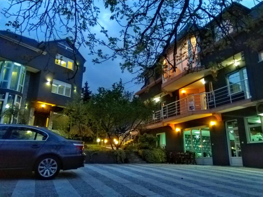 a car parked in front of a building at night at Garni Hotel Lama in Kragujevac