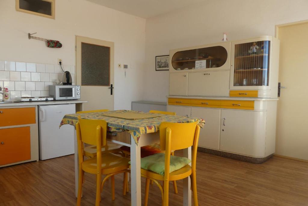 kuchnia ze stołem i żółtymi krzesłami w obiekcie Pacov 501 w mieście Pacov