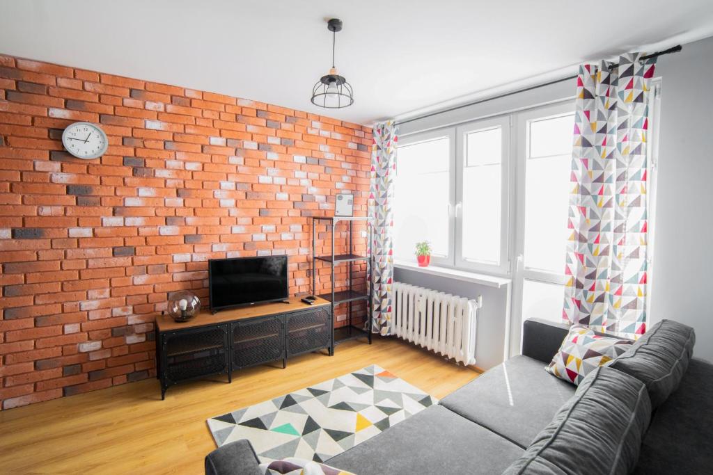 a living room with a brick wall at Apartament Dla Ciebie in Olsztyn