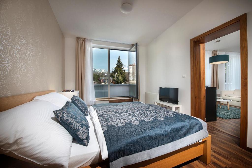 a bedroom with a large bed and a large window at Apartment No. 11, Apartment House Oliver in Štrbské Pleso