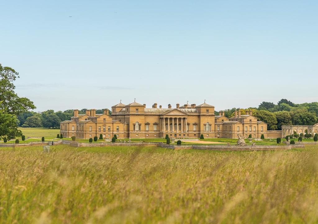 a large mansion in a field of grass at Victoria in Holkham