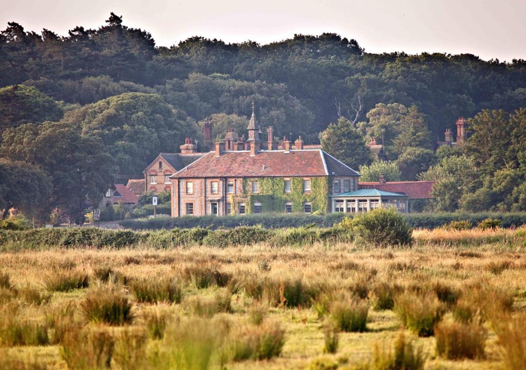 a large house in the middle of a field at Victoria in Holkham