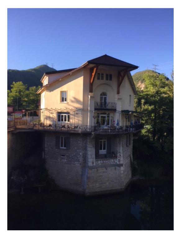 un grand bâtiment au-dessus de l'eau dans l'établissement L'Apogée, à Thoirette