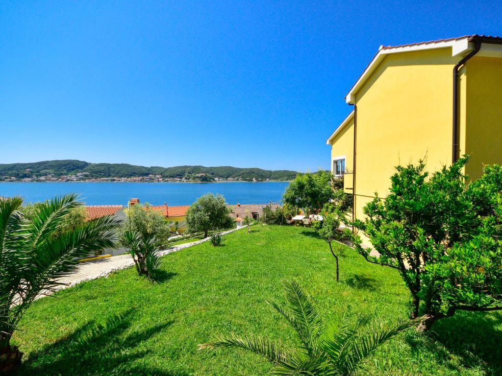 a yellow house with a view of the water at Studio Čipčić-2 by Interhome in Supetarska Draga