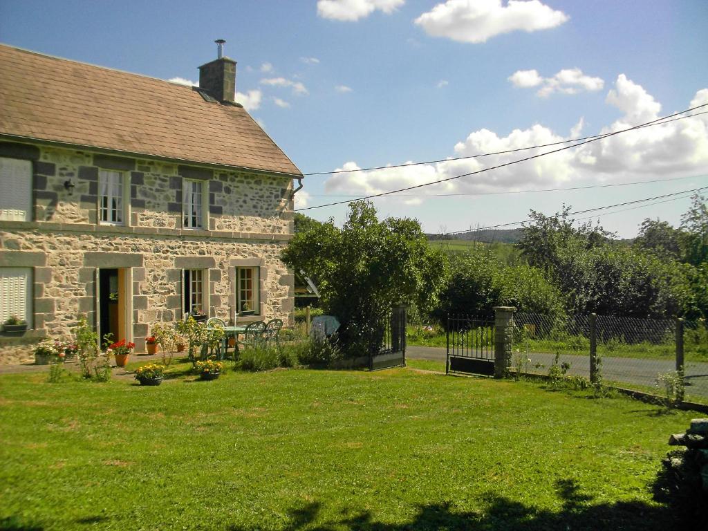 une ancienne maison en pierre avec une cour herbeuse dans l'établissement Holiday Home O'Petit Bonheur by Interhome, à Langlerial