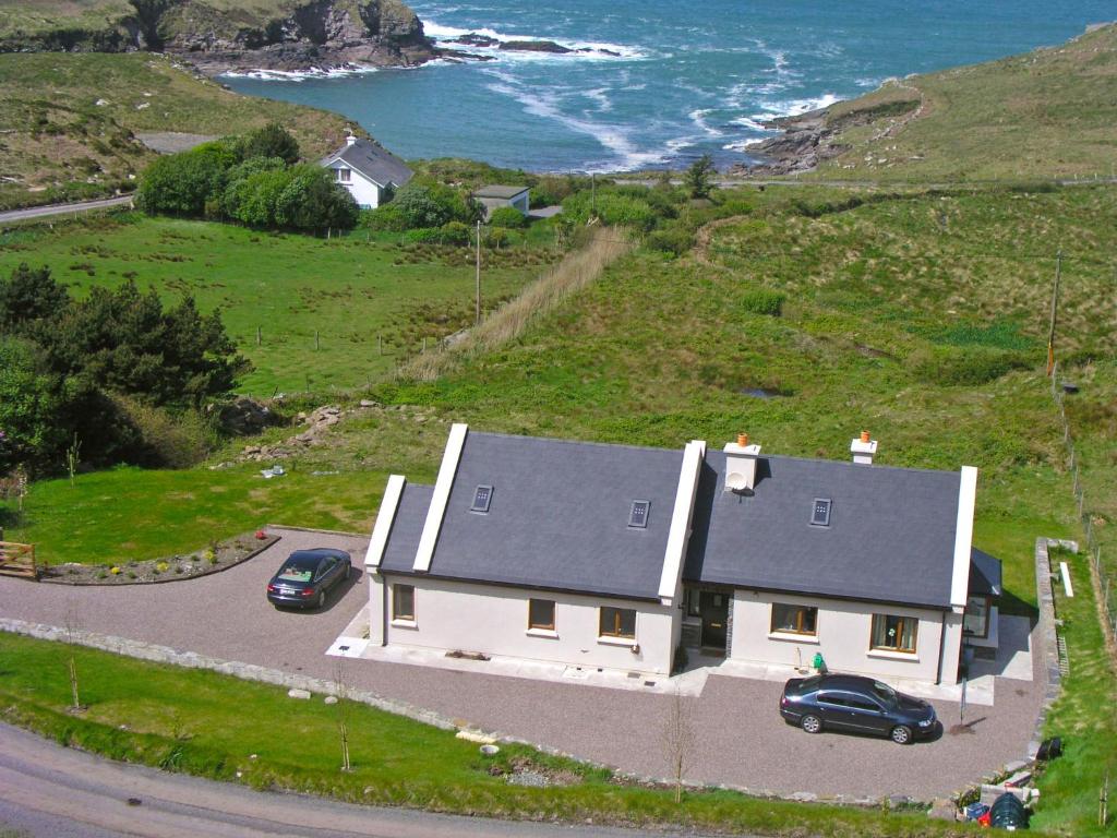 a house on a hill next to the ocean at Holiday Home Cuascrome by Interhome in Cahersiveen