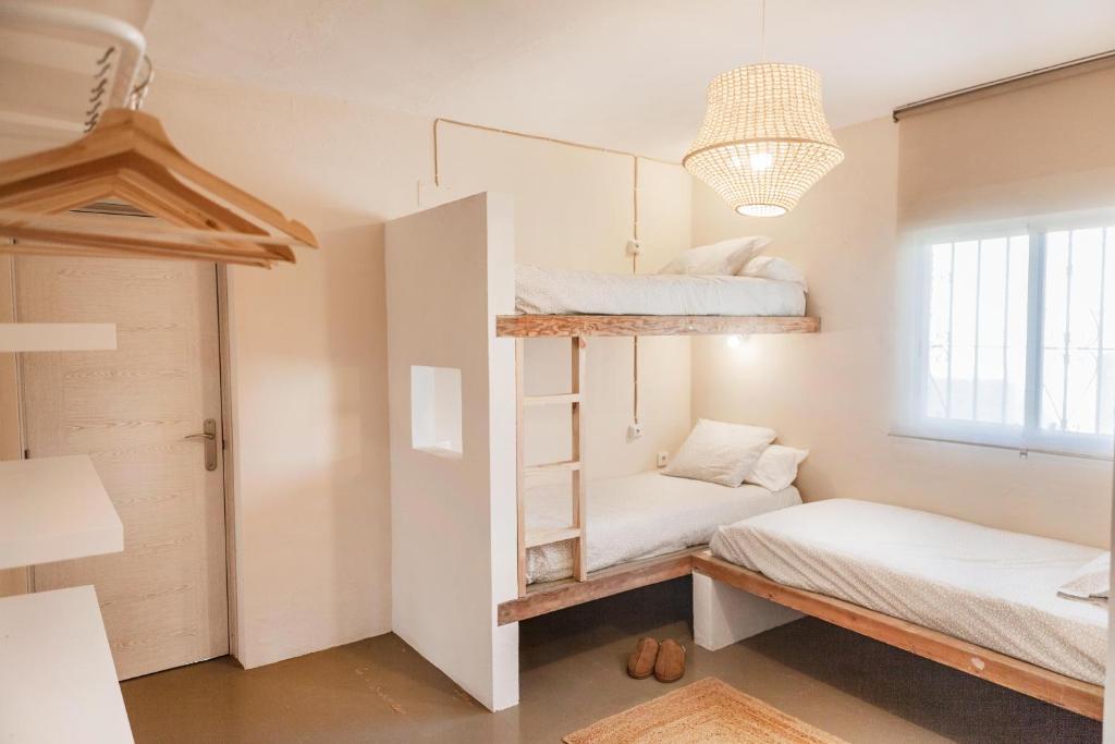 a room with two bunk beds and a chandelier at Wild House Tarifa in Tarifa