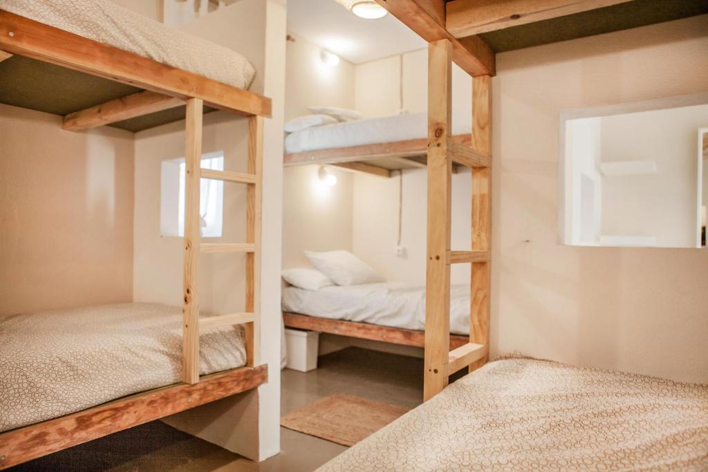 two bunk beds in a small room with two beds at Wild House Tarifa in Tarifa