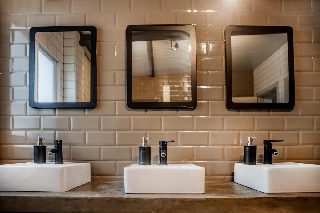 a bathroom with two sinks and two mirrors at Wild House Tarifa in Tarifa