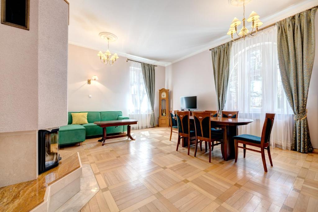 ein Wohnzimmer mit einem Tisch und einem grünen Sofa in der Unterkunft DR Apartments - Kos in Sopot