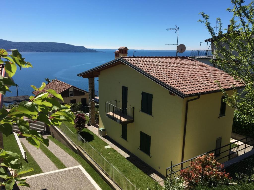 a yellow house with a view of the water at Casa Marina in Toscolano Maderno