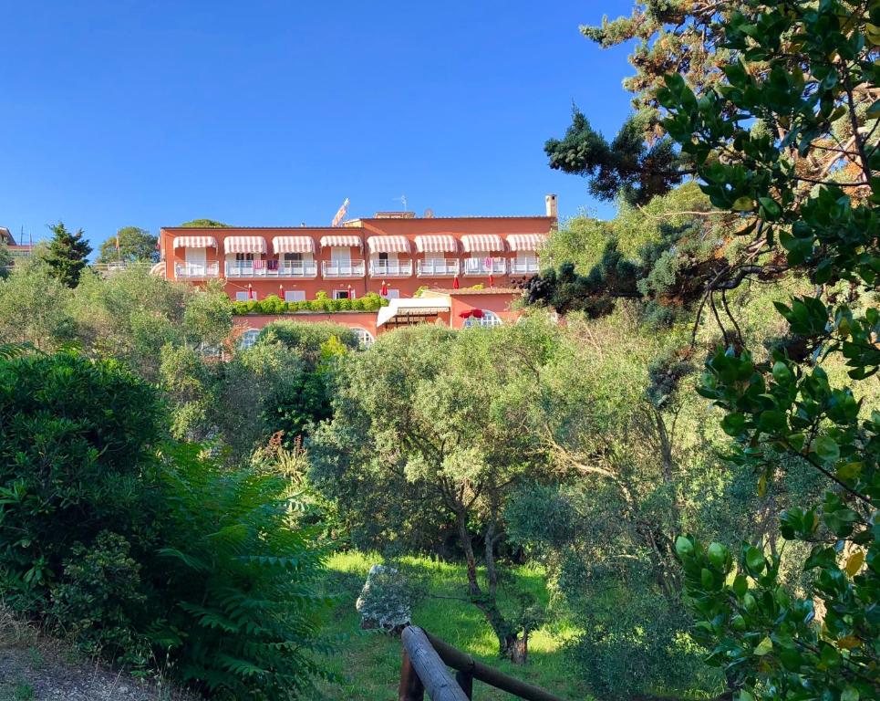 a large red building in the middle of a forest at Hotel Acquamarina in Portoferraio