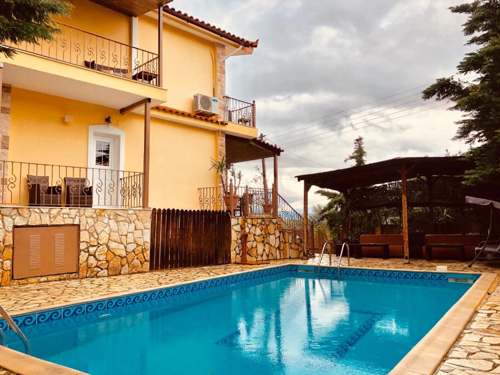 uma piscina em frente a uma casa em Villa Saron em Corinto