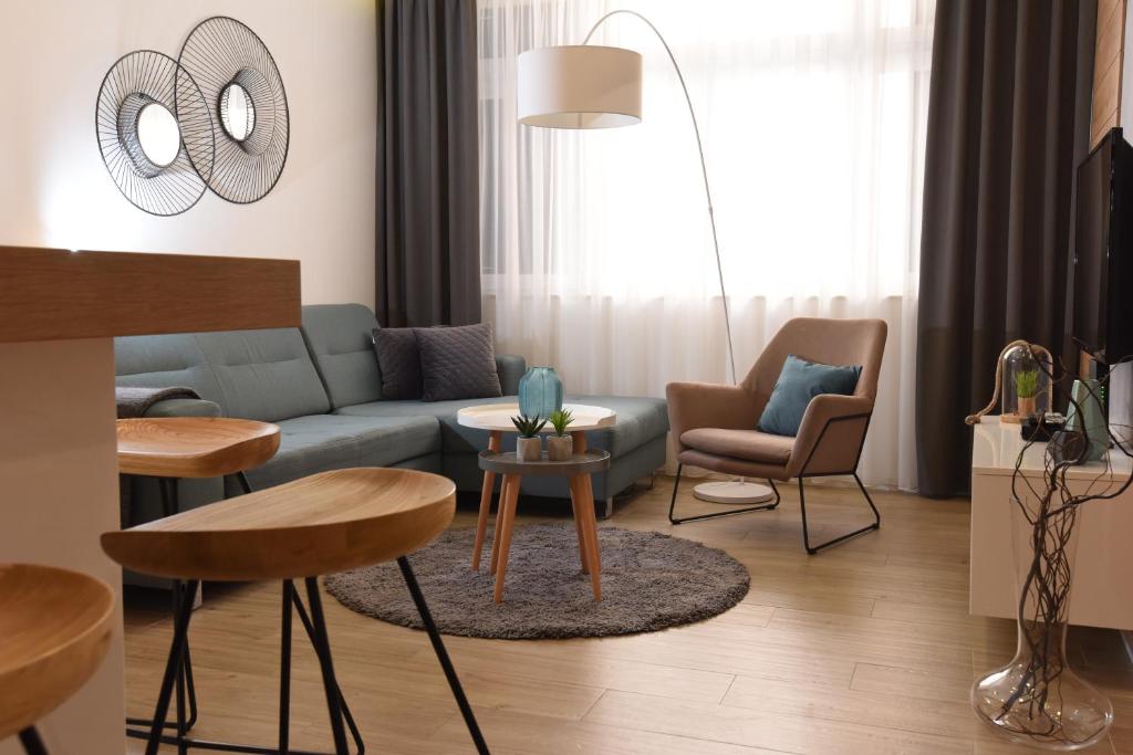 sala de estar con sofá azul y sillas en Apartment Speranza en Zadar