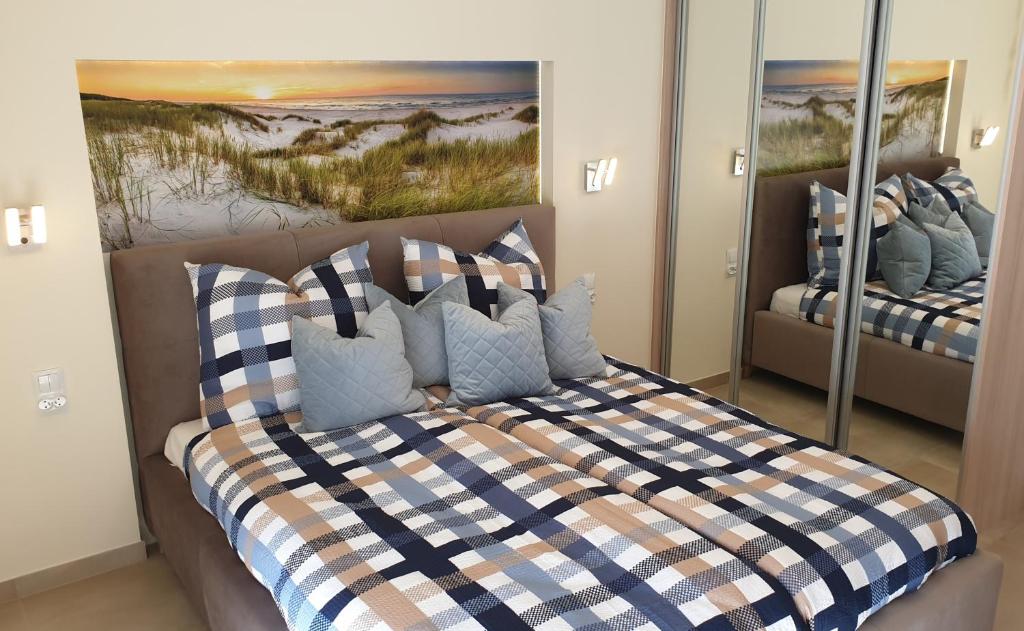 a bedroom with a bed with a checkered blanket at Apartment Sunrise in Świnoujście
