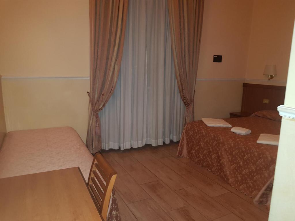 Postel nebo postele na pokoji v ubytování Hotel Aristotele