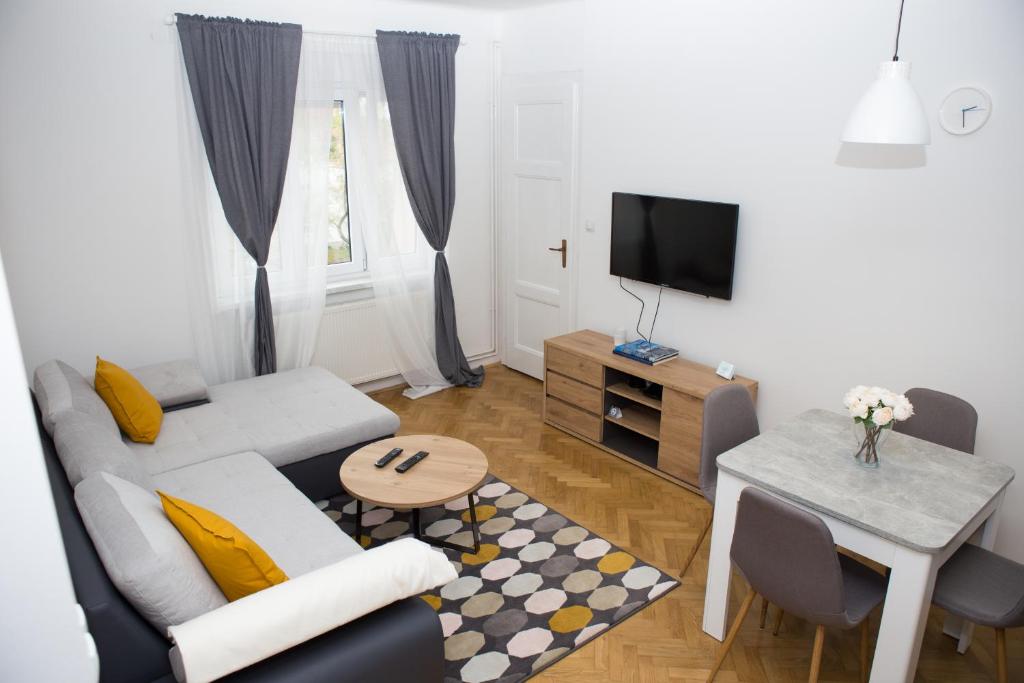 - un salon avec un canapé et une table dans l'établissement Deluxe Apartments Zagreb, à Zagreb