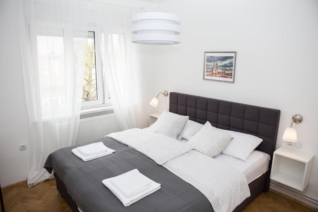 een slaapkamer met een groot bed en 2 witte handdoeken. bij Deluxe Apartments Zagreb in Zagreb