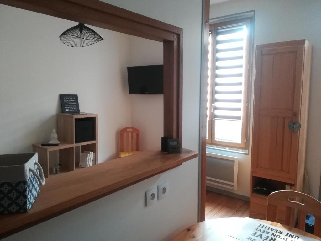 um quarto com um espelho, uma mesa e uma janela em Les Néréides em Mers-les-Bains