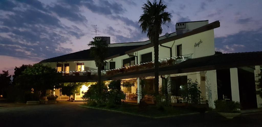 a building with palm trees in front of it at B&B Cà d'Artisti in Caorle