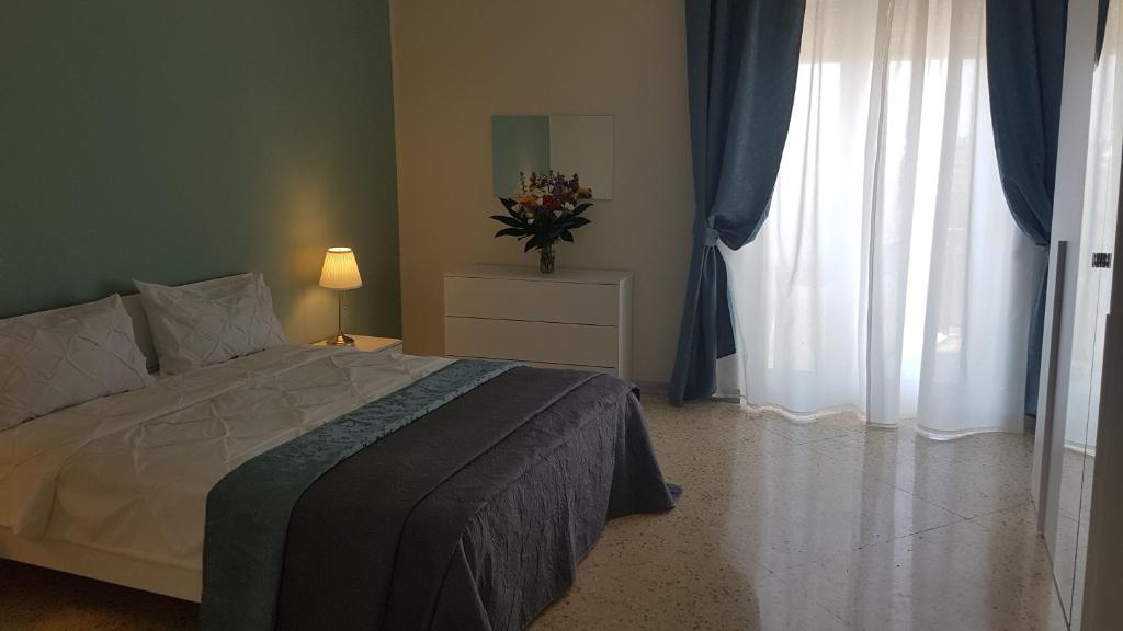 a bedroom with a bed and a vase of flowers at Residenze Benedetto Croce in Bari