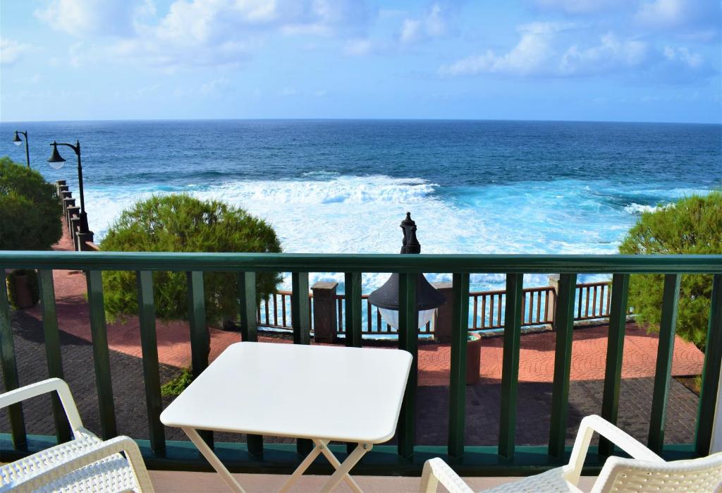 einen Balkon mit einem weißen Tisch, Stühlen und Meerblick in der Unterkunft La Fajana Paradise in Barlovento
