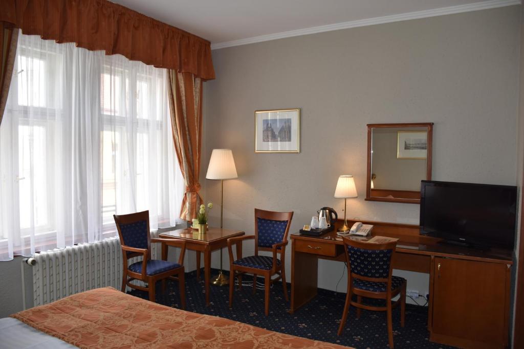 a hotel room with a bed and a desk with a computer at Arbes in Prague