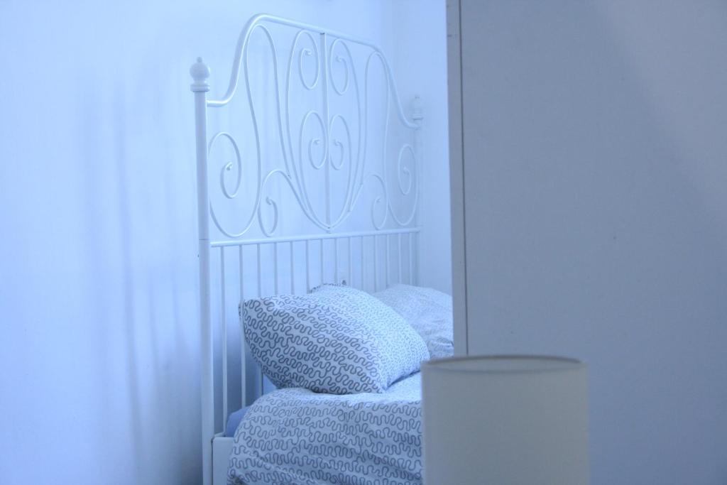 Bett mit einem weißen Kopfteil und einem Kissen in der Unterkunft Sleepover City Center GuestRooms in Budapest