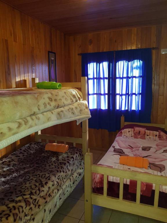zwei Etagenbetten in einem Zimmer mit Fenster in der Unterkunft Cabaña del Iguazu in Puerto Iguazú