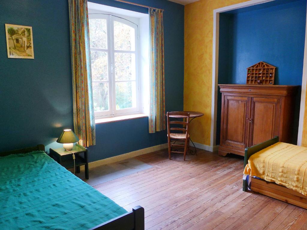 a bedroom with blue walls and a bed and a window at Holiday Home Le chant des milans by Interhome in Ondres