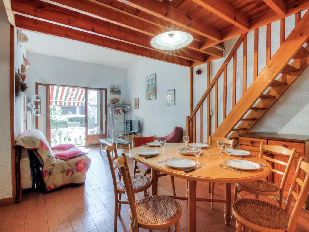 een eetkamer met een houten tafel en stoelen bij Holiday Home Juncades by Interhome in Seignosse