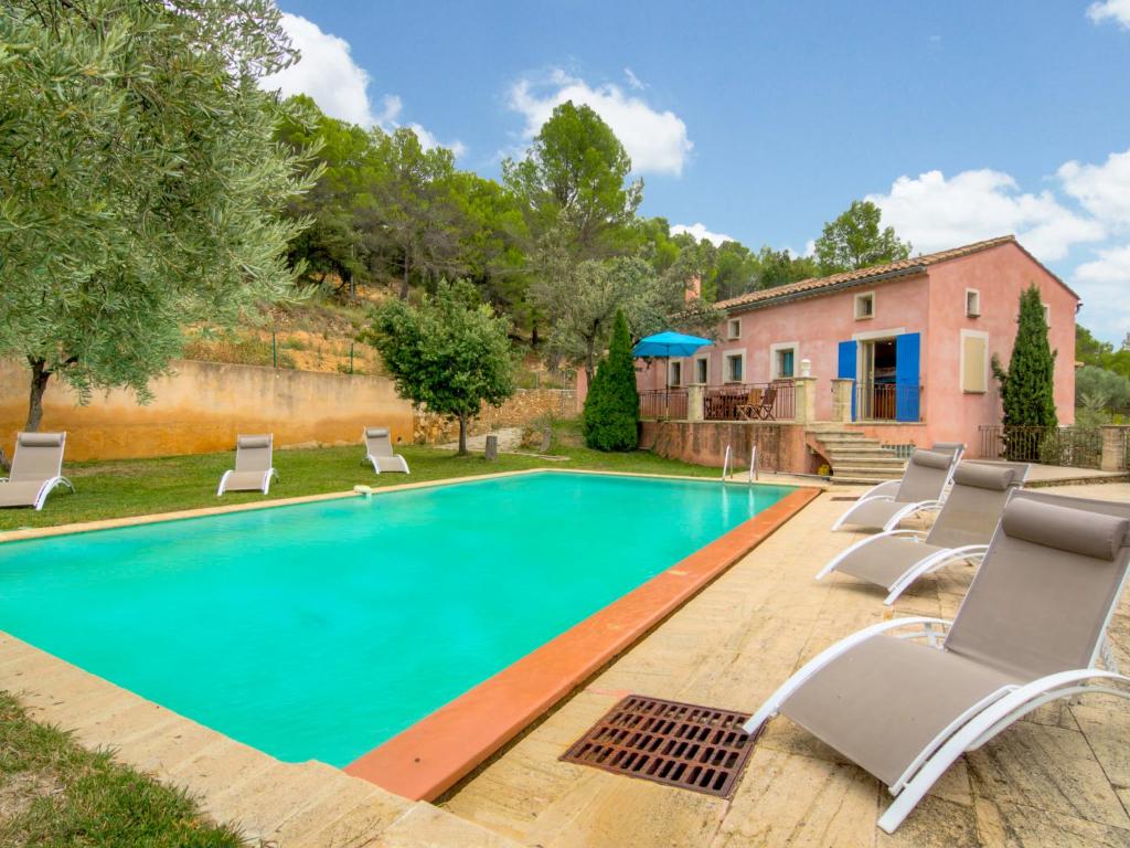 einen Pool mit Liegestühlen und ein Haus in der Unterkunft Holiday Home Patifiage by Interhome in Le Barroux