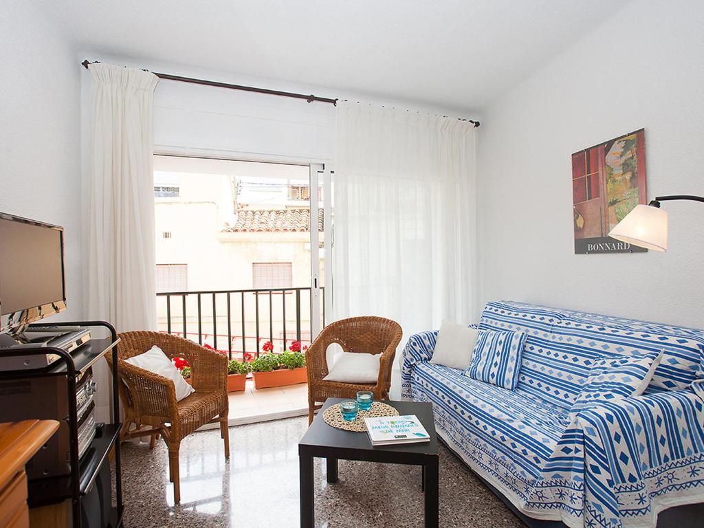 ein Wohnzimmer mit einem Sofa und einem Balkon in der Unterkunft Apartment Sant Pol by Interhome in San Pol de Mar