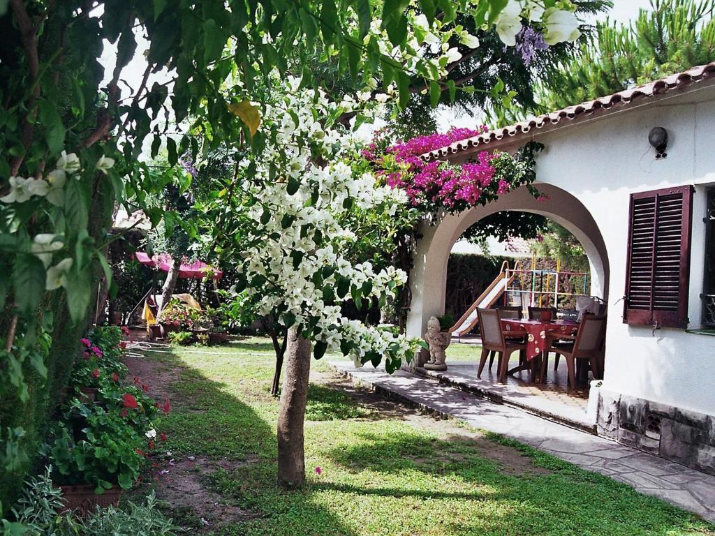 ビラフォルトゥニーにあるHoliday Home Vilafortuny by Interhomeの白い花の木とテーブルのある庭園