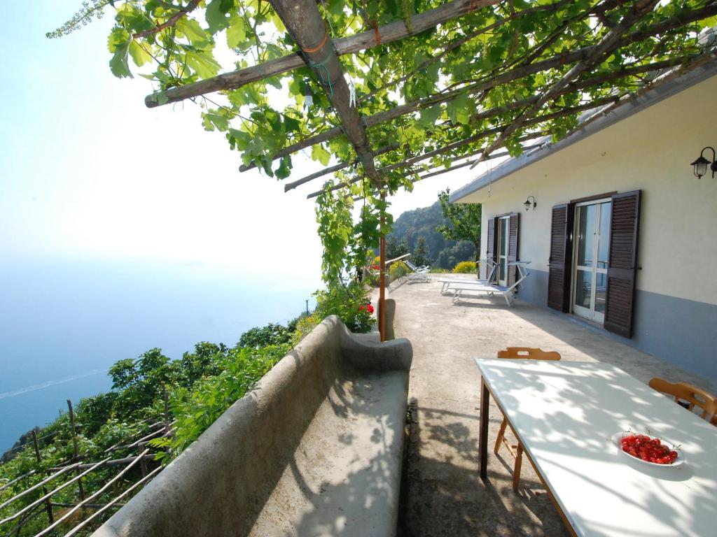 a house with a table and a view of the ocean at Holiday Home Path of the Gods by Interhome in Pianillo