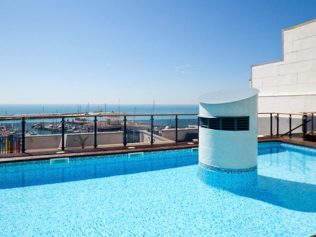 una piscina en la parte superior de un edificio con el océano en Apartment Edificio Nautic by Interhome, en L'Ampolla