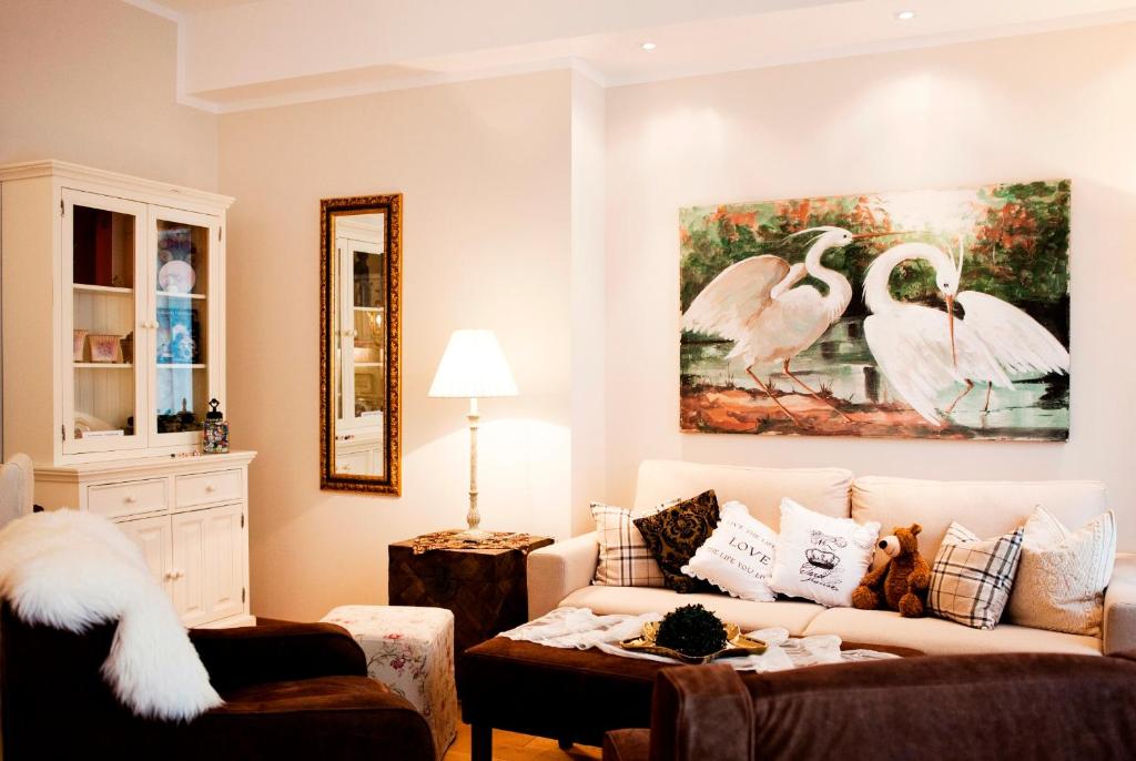 a living room with a couch and a painting of swans at Schottennester Schlafen an der Krämerbrücke in Erfurt